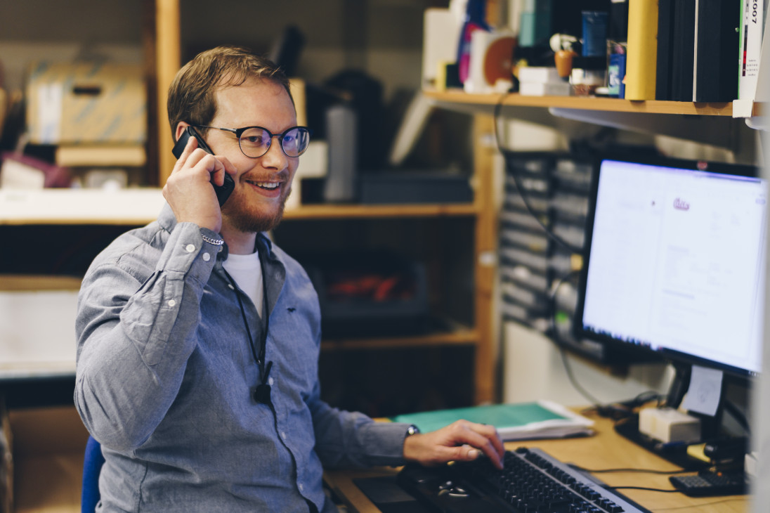 A man on the phone in technical support at Micropower