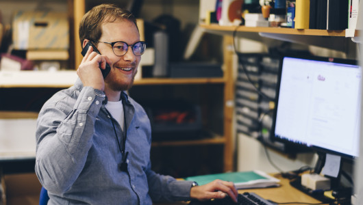 A man on the phone in technical support at Micropower