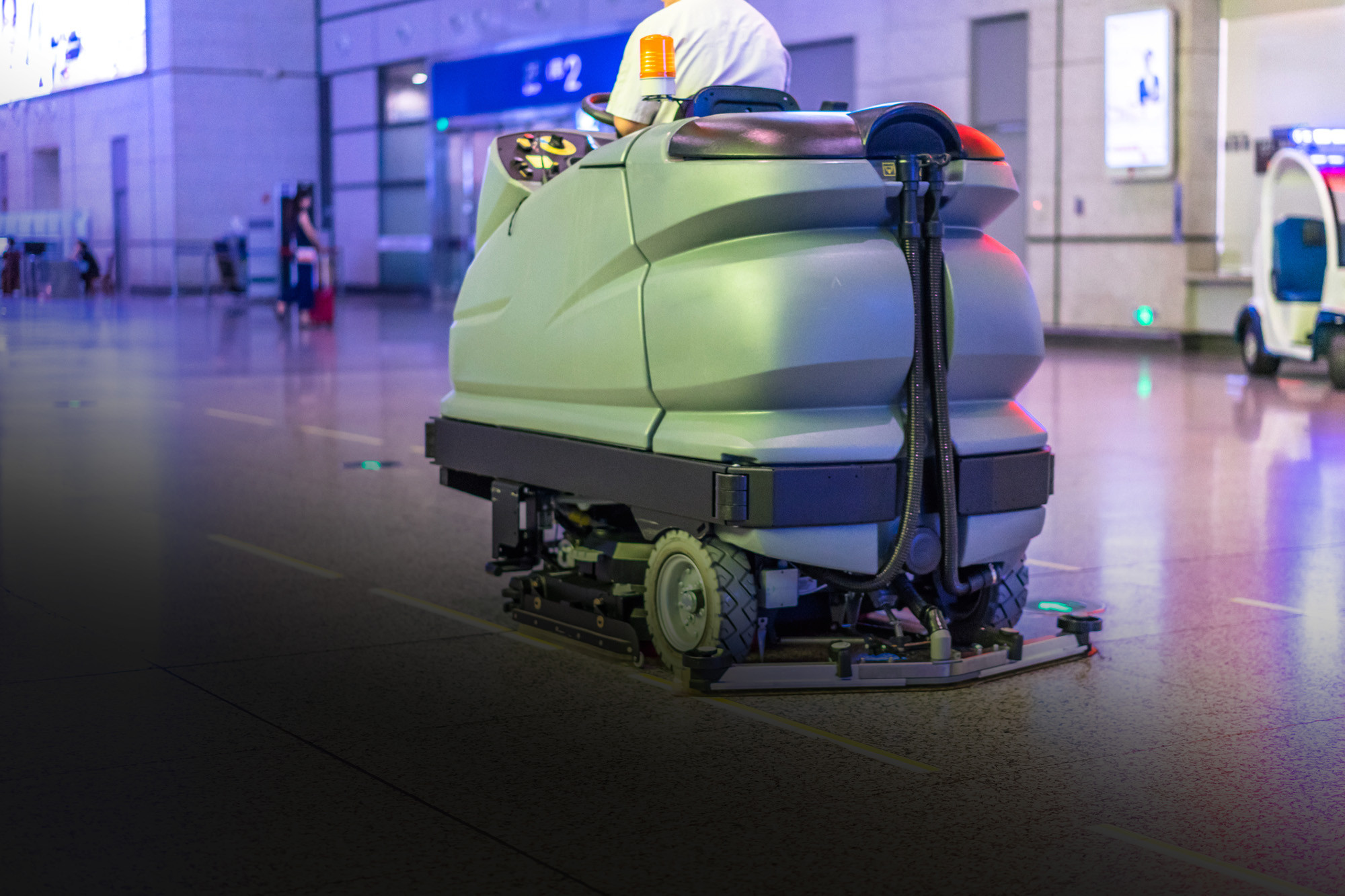 A green electric cleaning machine tidying up the industry floor
