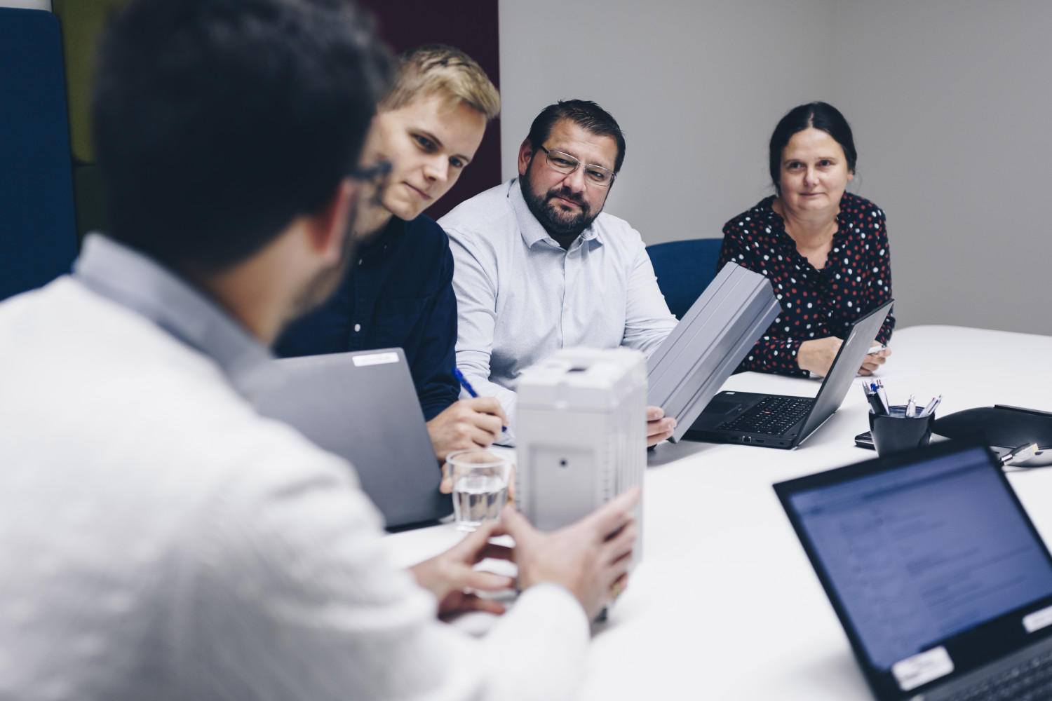 Four persons at Micropower Group are in a meeting, listening and talking.